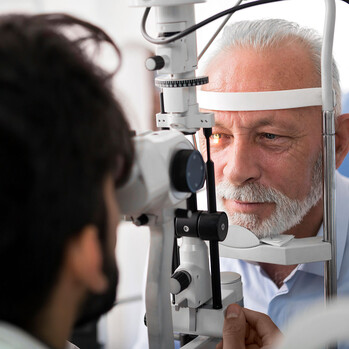 Das Gesicht eines älteren Herren während einer optischen Kohärenztomographie (OCT) in der Nahaufnahme